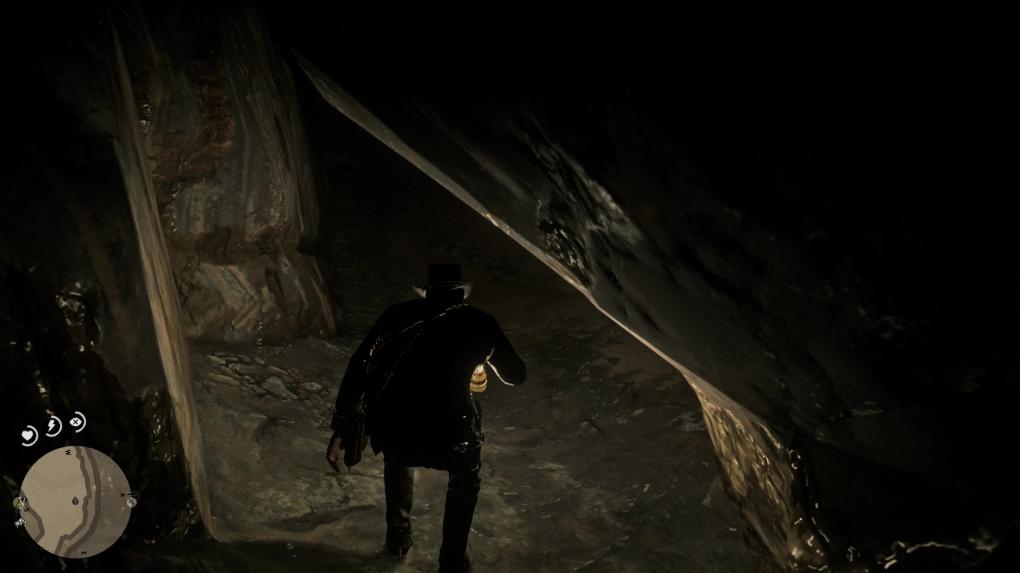 Arthur zwängt sich in RDR2 hindurch durch die Höhle.