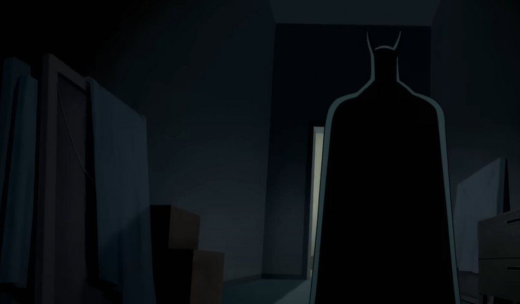 Batman von hinten steht vor einem beleuchteten Zimmer