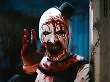 Der Horror-Clown aus Terrifier 2 lächelt bedrohlich in die Kamera.