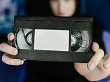 Eine VHS-Kassette wird ins Bild gehalten.