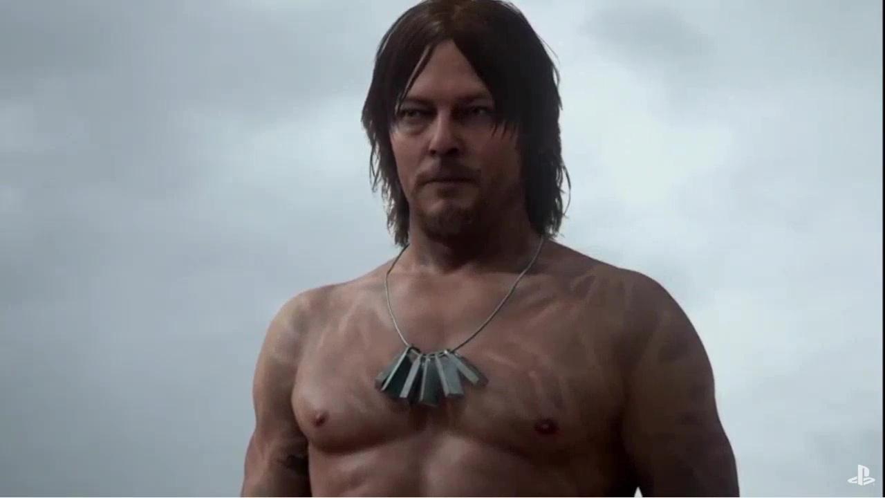 Der Hauptcharakter von Death Stranding steht mit nacktem Oberkörper am Strand.
