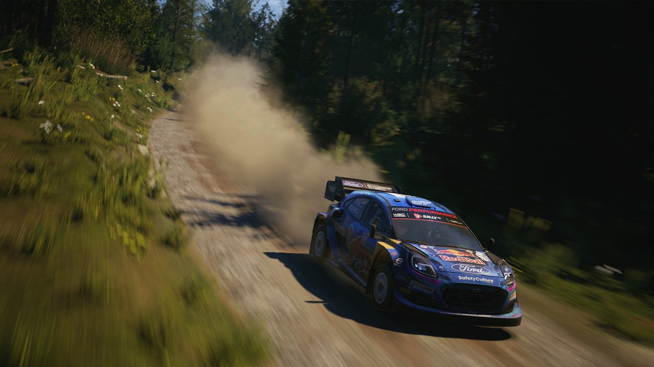 Ein Ford-Rallyeauto fährt über eine staubige Piste.