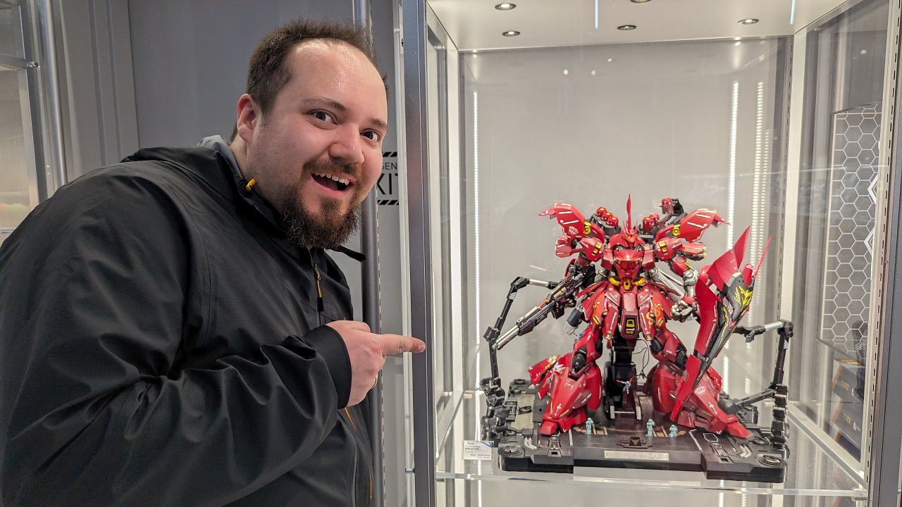 [08/04/2024] Ich vor einer schicken Mobile-Suit-Figur (der wunderschöne Sazabi) aus dem Gundam-Kosmos. Hoffentlich zeig ich am Ende genauso begeistert auf meinen Bildschirm, auf dem die Netflix-Verfilmung