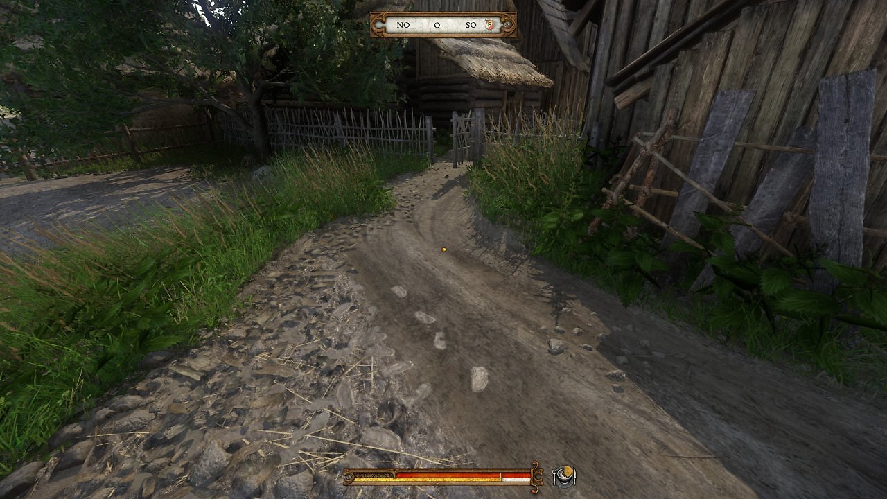 Ein Feldweg, der zu einem kleinen Gartentor führt.