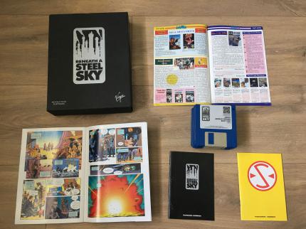 Spielepackung anno 1994: In dem Karton von Beneath a Steel Sky liegen ein Comic von Dave Gibbons, die Spielanleitung, ein 'Staatsschutz- Handbuch' mit Infos über Charaktere und Spielwelt, ein Stapel Amiga-Disketten und Spiele-Werbung bei.