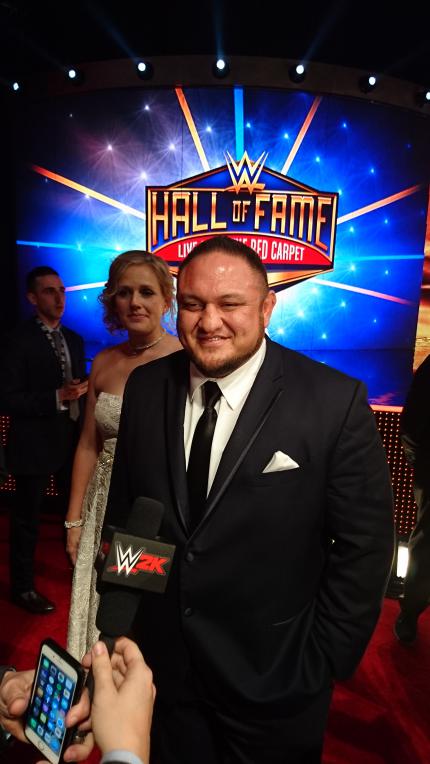 Bei der Hall of Fame drücken sich aktuelle Stars und Legenden die Klinke in die Hand. Samoa Joe hat jedenfalls bessere Laune als am Morgen.