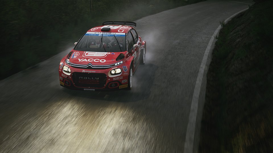 Ein Rennauto fährt über eine nächtliche Rallyepiste.